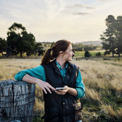 Young farmer staying in touch via mobile technology from their rural farm